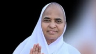 Woman wearing a white headscarf holding hands in a blessing gesture.