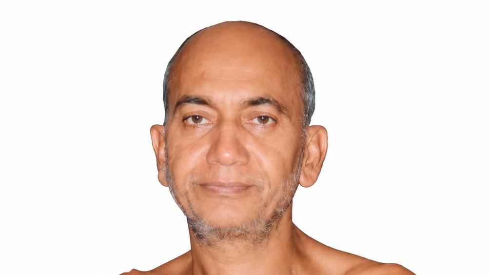 Portrait of a middle-aged man with a bald head and light stubble against a white background.