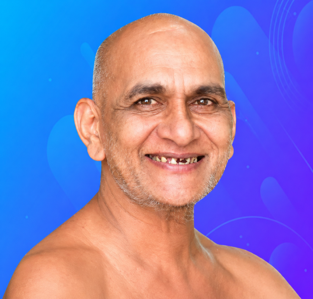 Smiling bald man with light stubble on his chin and cheeks, shown from shoulders up against a blue abstract background.