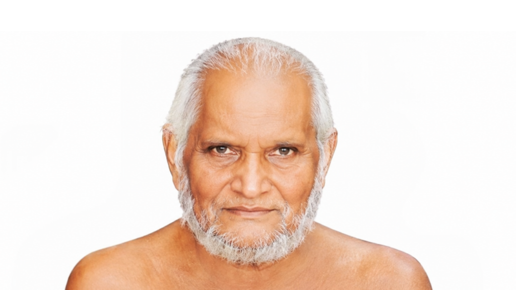 Older man with short white hair and a full gray beard, looking directly at the camera against a white background.