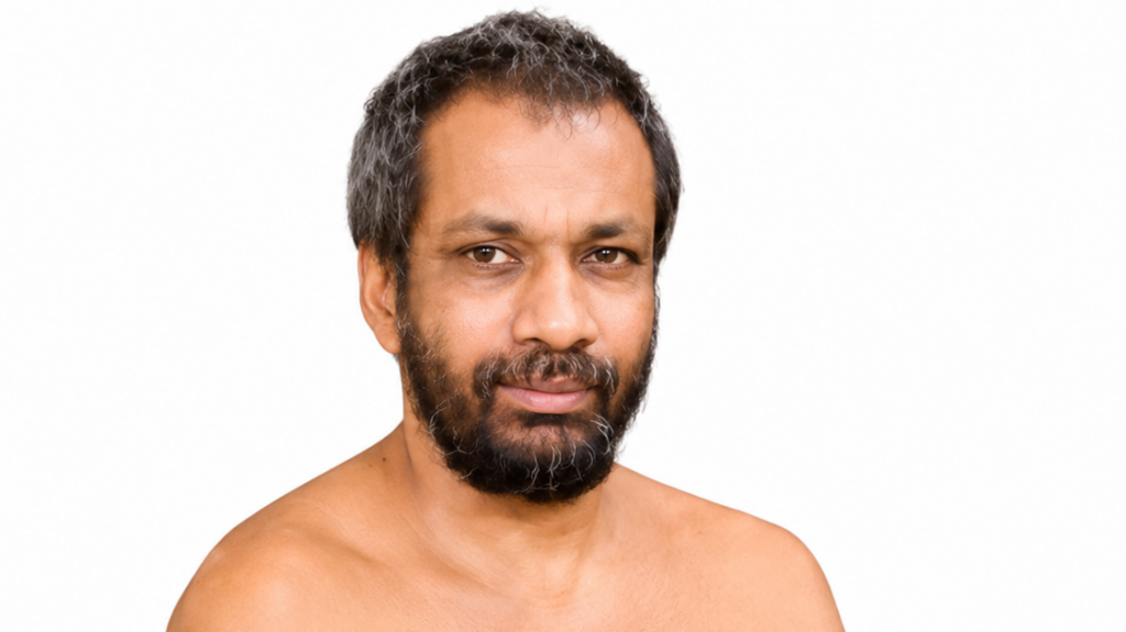 Close-up portrait of a bearded man looking at the camera against a plain white background.