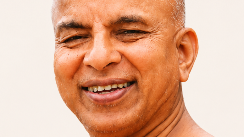 Close-up portrait of a smiling man with a tan complexion, showing teeth and crow's feet at the eyes.