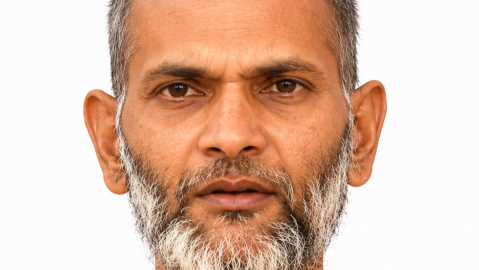 Close-up of a middle-aged man with a gray beard and mustache against a white background, looking straight ahead.