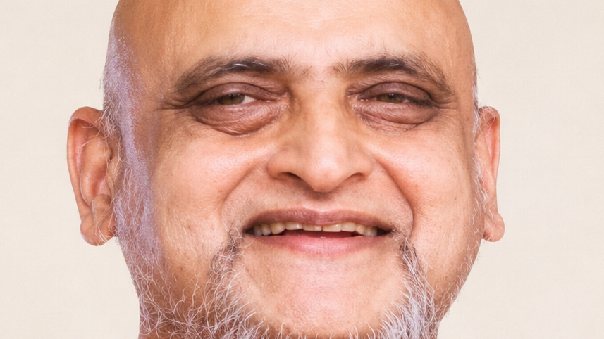 Close-up of a smiling older man with a bald head and gray beard against a light background.