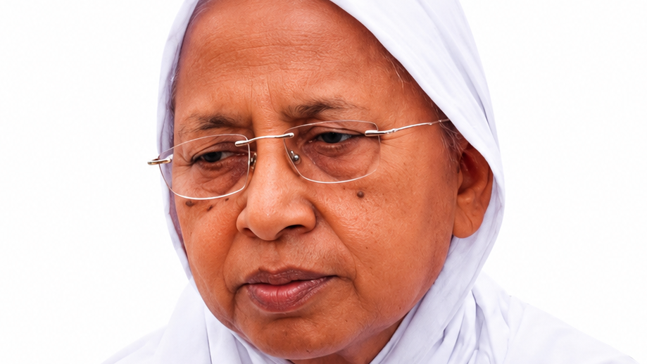 Close-up of an older woman wearing a white headscarf and glasses, looking thoughtful.