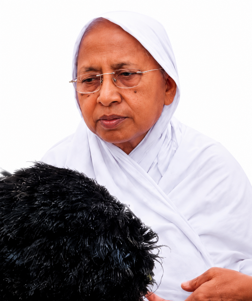 Elderly woman in a white headscarf gently holding a black chicken against a white background.