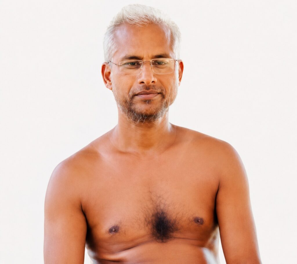 Portrait of a middle-aged man with short gray hair and glasses, bare chest, facing the camera.