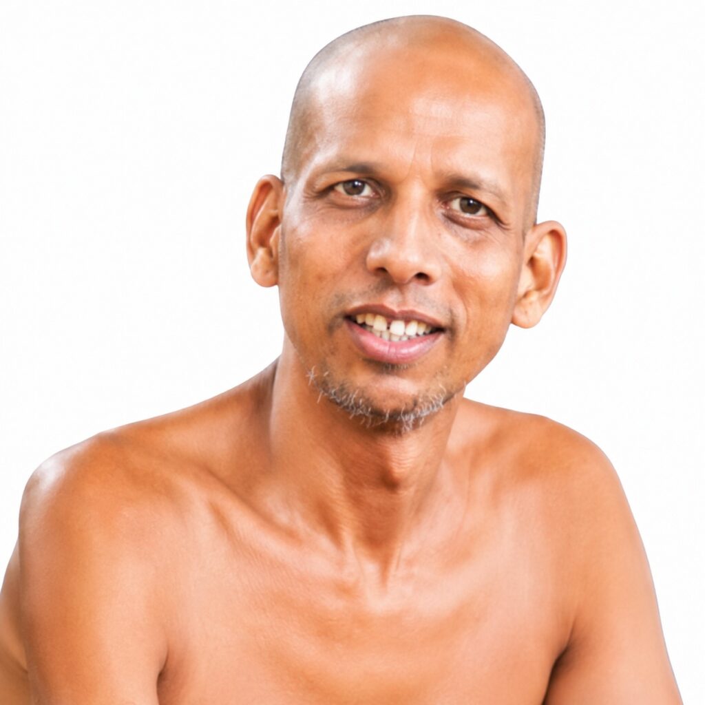 Portrait of a smiling, bald man with a light gray goatee, shown from the chest up against a white background.