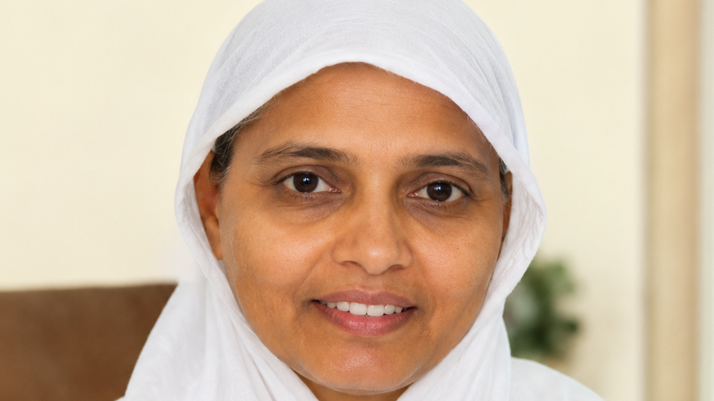 Close-up portrait of a smiling woman wearing a white headscarf. Portrait-style photo suitable for a personal or professional profile.