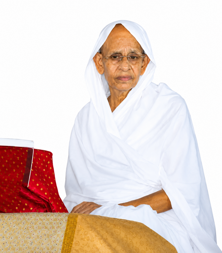 Elderly woman in a white traditional dress and head covering, seated beside a red book on a gold-embroidered tablecloth.