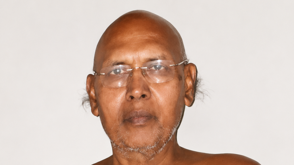 Portrait of a middle-aged man wearing glasses with a light gray beard against a plain light background.