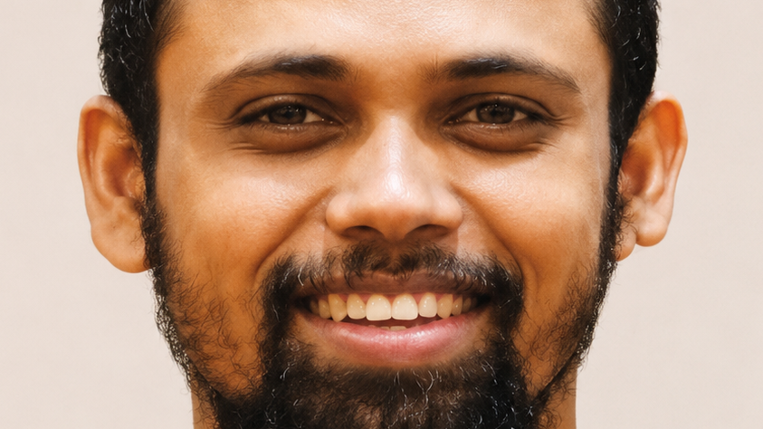 Close-up portrait of a man with a beard smiling at the camera.