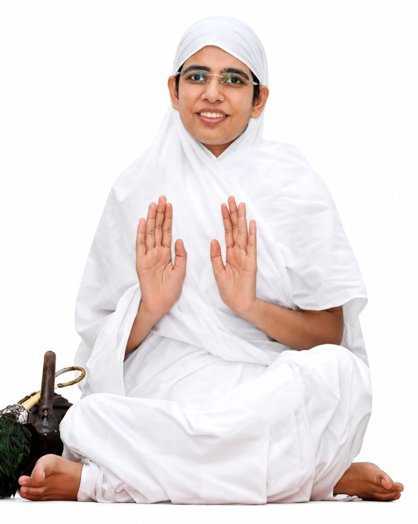 Woman in white traditional clothing sits cross‑legged with palms raised in prayer against a white background.