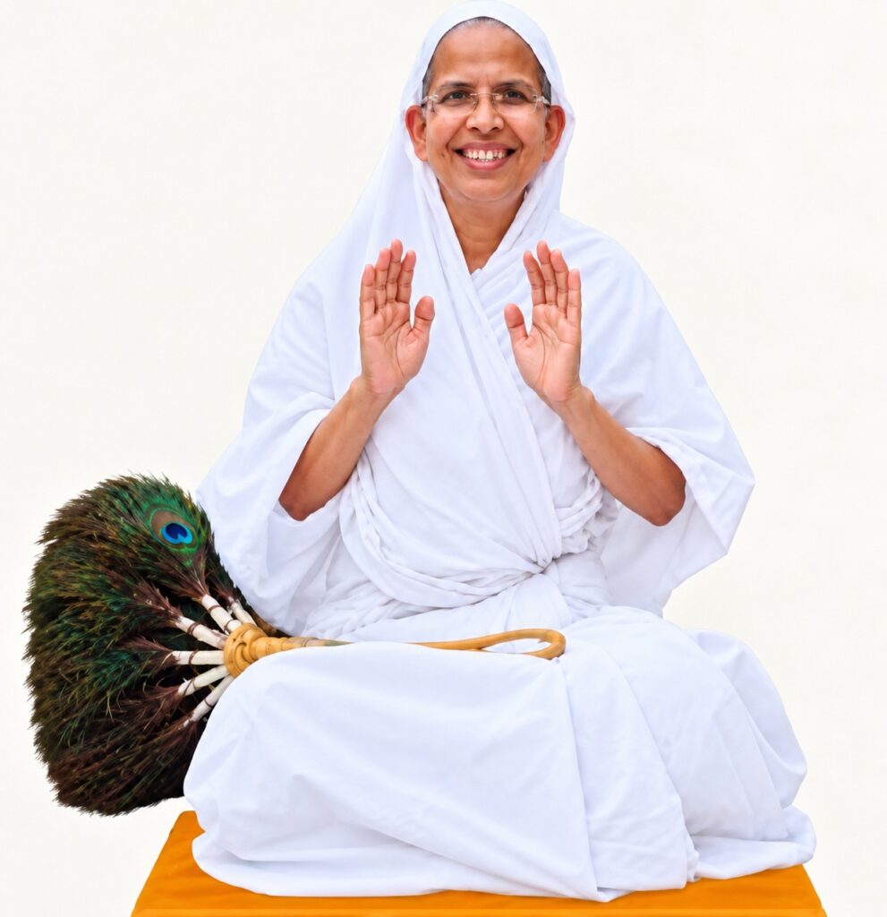 Smiling woman in white robes sits cross-legged on an orange mat, hands raised in a calm blessing gesture, with a peacock feather fan beside her.