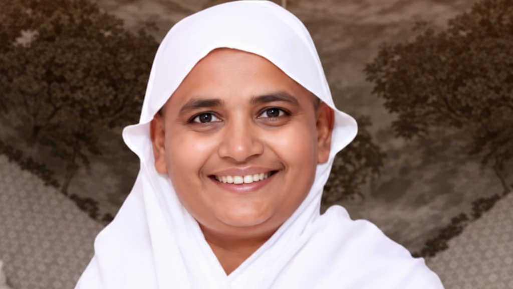 Smiling woman wearing a white hijab, facing the camera.