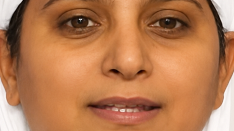 Close-up of a person’s face with a neutral expression, lying down, eyes open and looking forward.