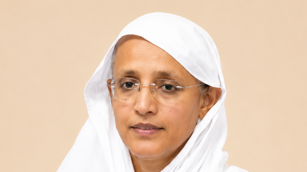 Woman wearing a white headscarf and glasses, looking slightly to the left, with a neutral expression against a beige background across a plain portrait.