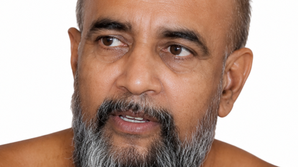 Close-up portrait of a middle-aged man with a gray beard looking to his left against a white background.