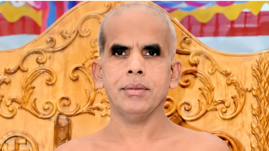 Portrait of a bald man with a calm expression, seated before an ornate carved wooden throne behind him.