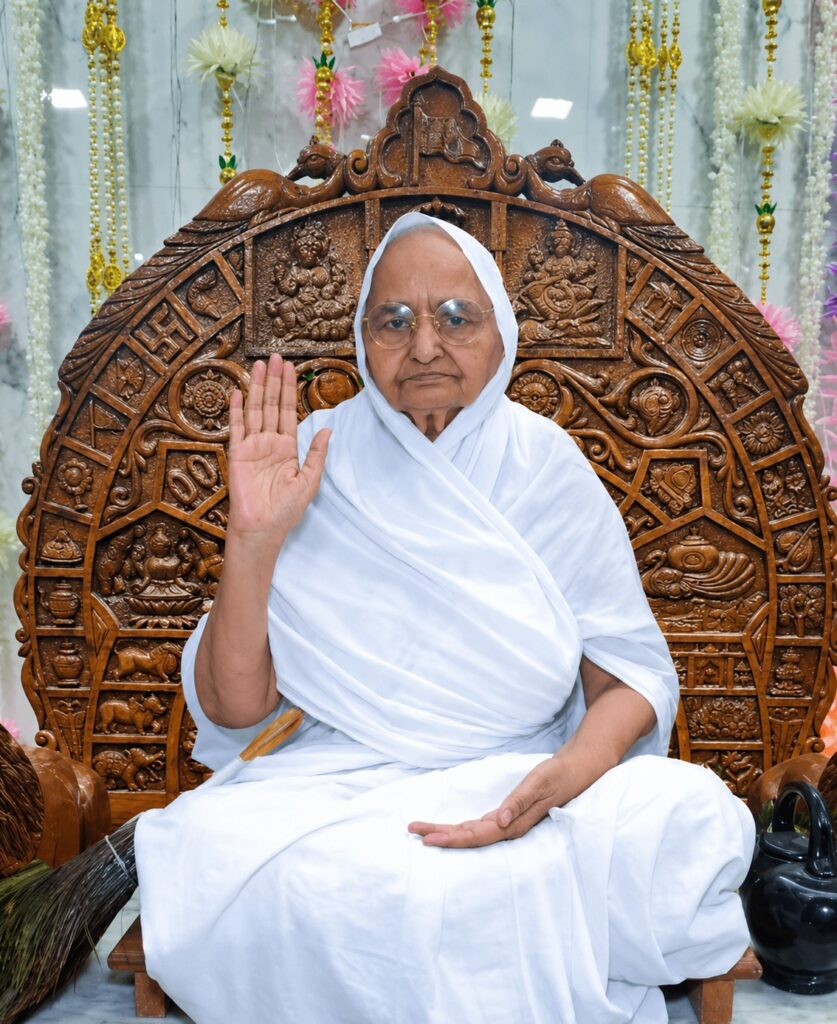 Elderly woman in a white robe sits on an ornate carved wooden throne, raising her right hand in blessing with a calm expression.