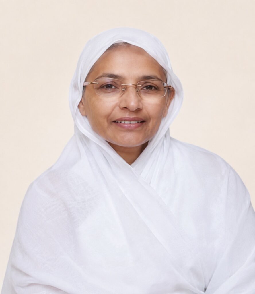 Smiling woman in a white headscarf and glasses against a pale beige background.