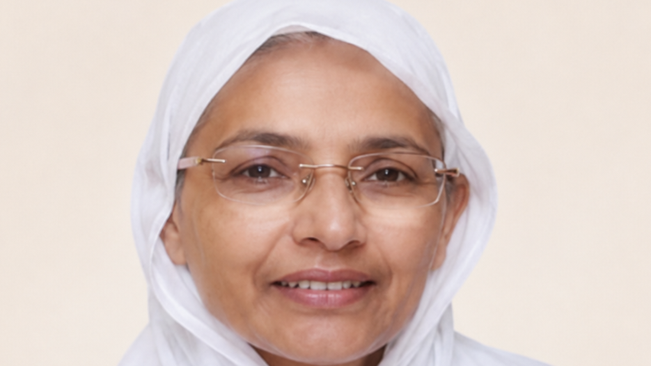 Smiling woman wearing a white hijab and glasses, facing the camera.