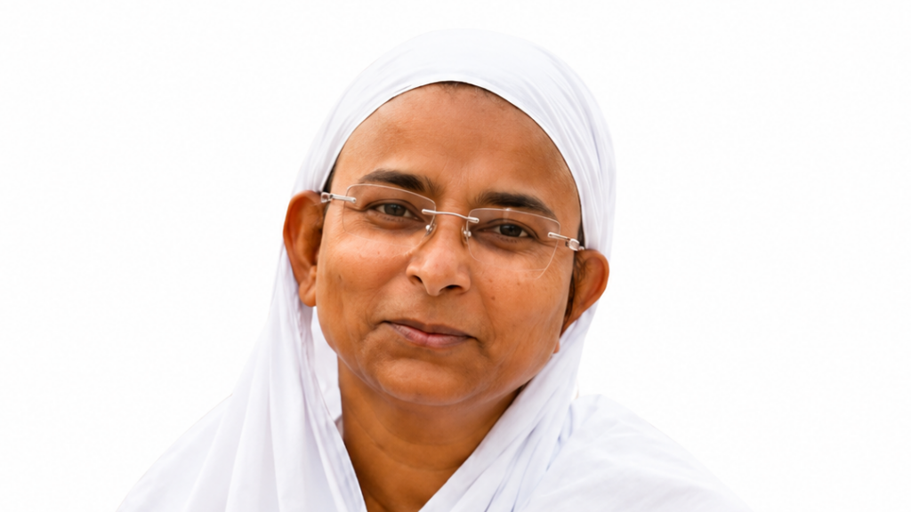 Smiling woman wearing a white headscarf and glasses, posed against a white background.