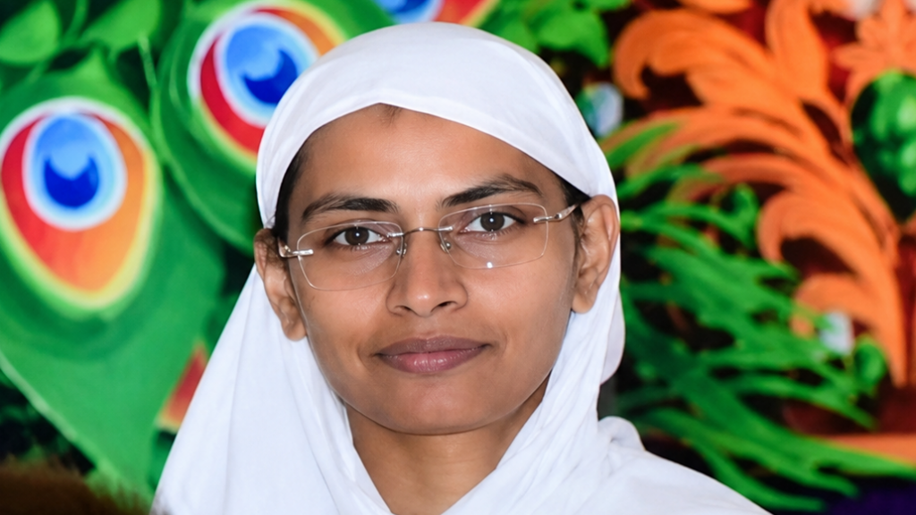 Portrait of a woman in a white hijab and glasses, smiling, with a colorful mural behind her.