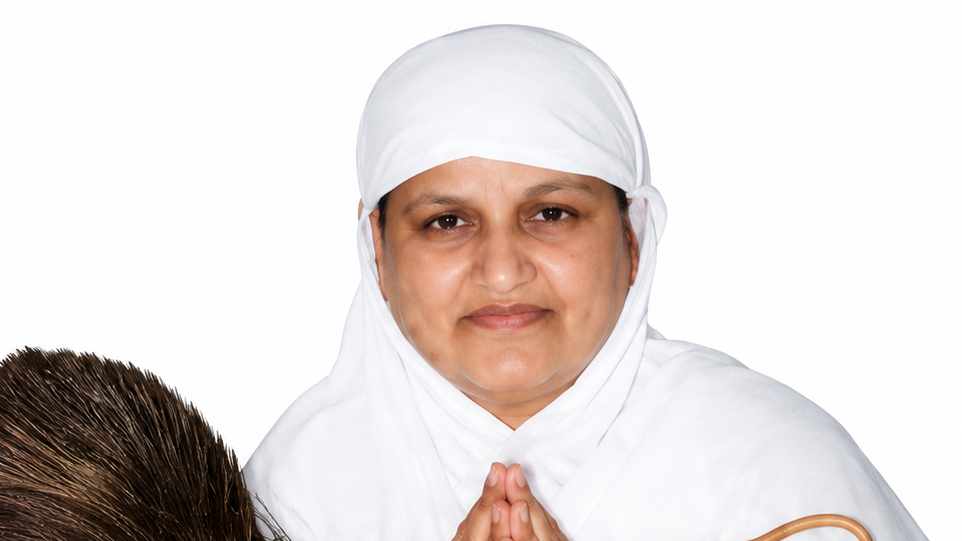 Woman in a white headscarf and robe smiling with hands pressed together in a prayer-like gesture against a white background.