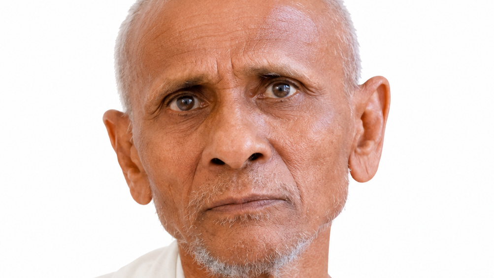 Close-up portrait of an older man with short white hair and a light gray beard, looking worried against a white background.