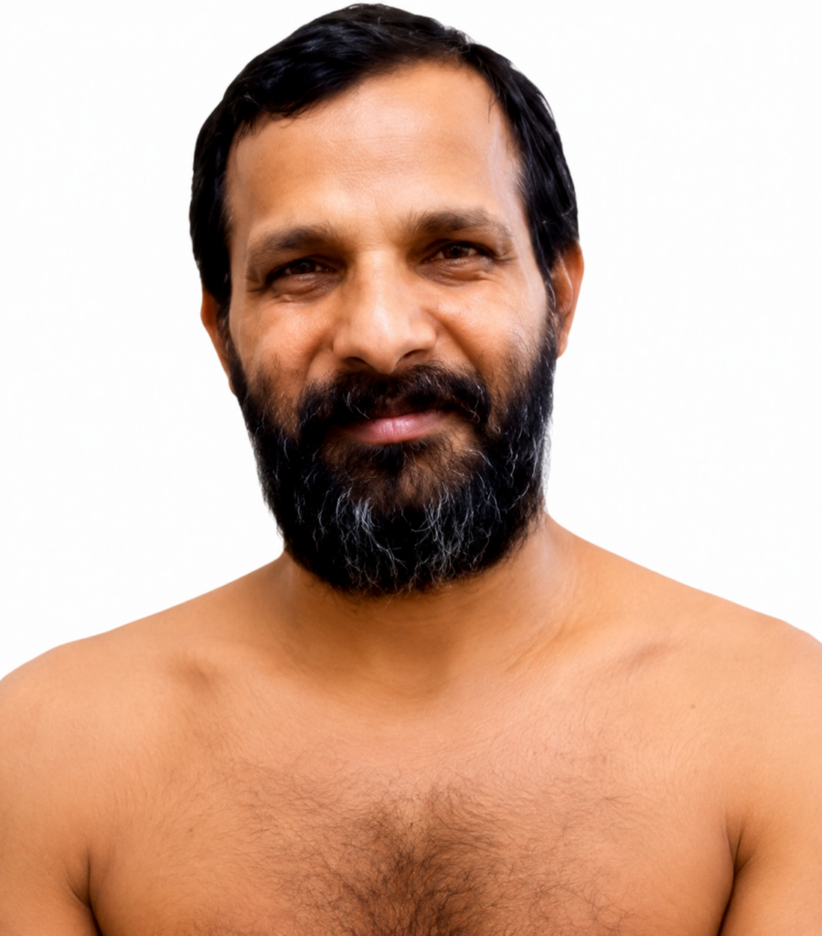 Portrait of a bearded man with dark hair and a friendly smile, bare shoulders against a white background.