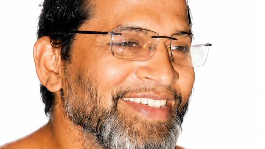 Close-up of a smiling man with a gray beard and rectangular glasses.