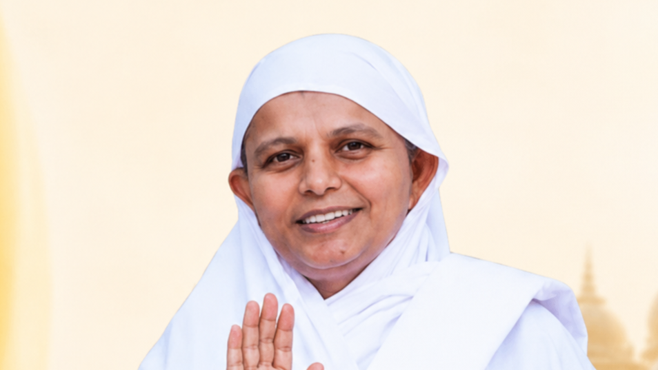 Smiling woman in a white headscarf and robe, raising her hand in a blessing gesture against a pale backdrop.