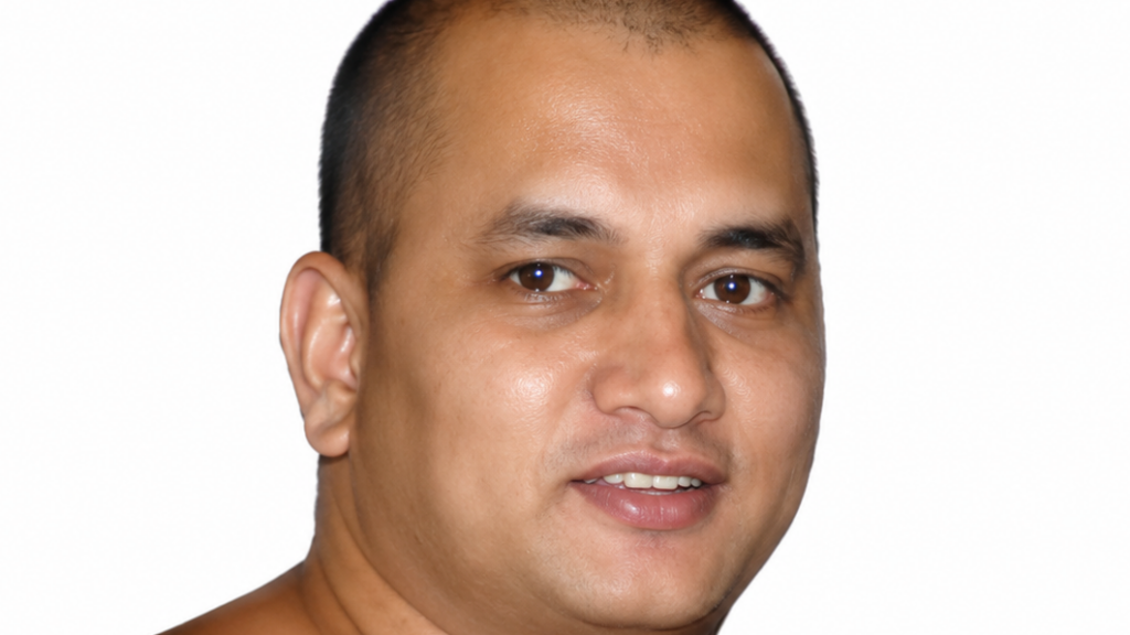 Close-up portrait of a man with short hair, slightly smiling, against a white background.