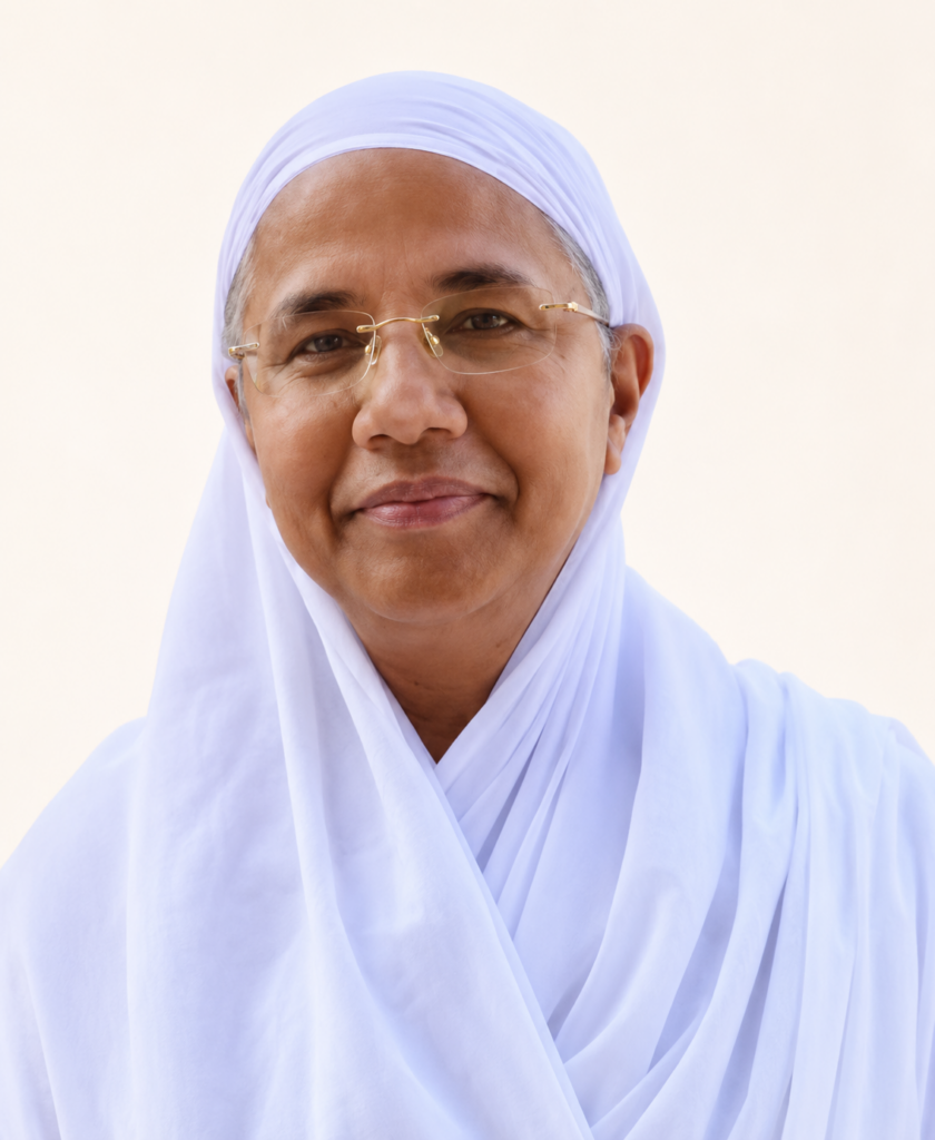 Smiling woman wearing a white hijab and gold-rimmed glasses against a light background as a portrait.
