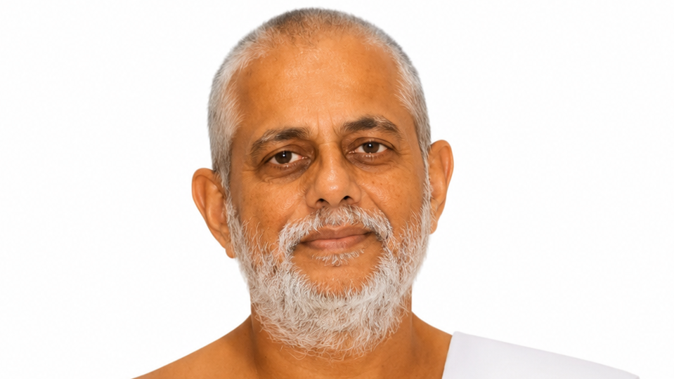 Portrait of an older man with a gray beard looking at the camera, wearing a white garment against a white background.