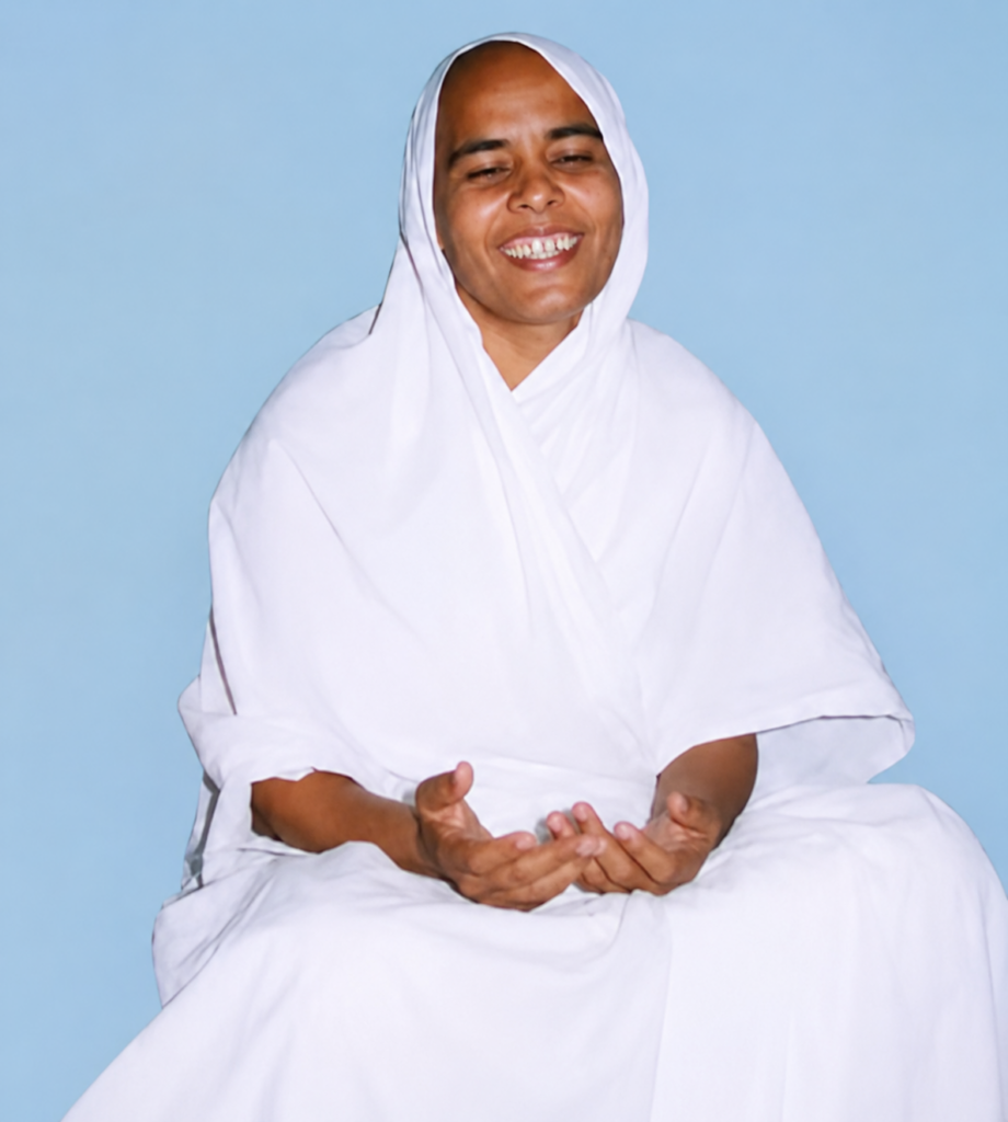 Person in white robes sits cross-legged, smiling with palms open in a gentle gesture against a light blue background, conveying calm and warmth.