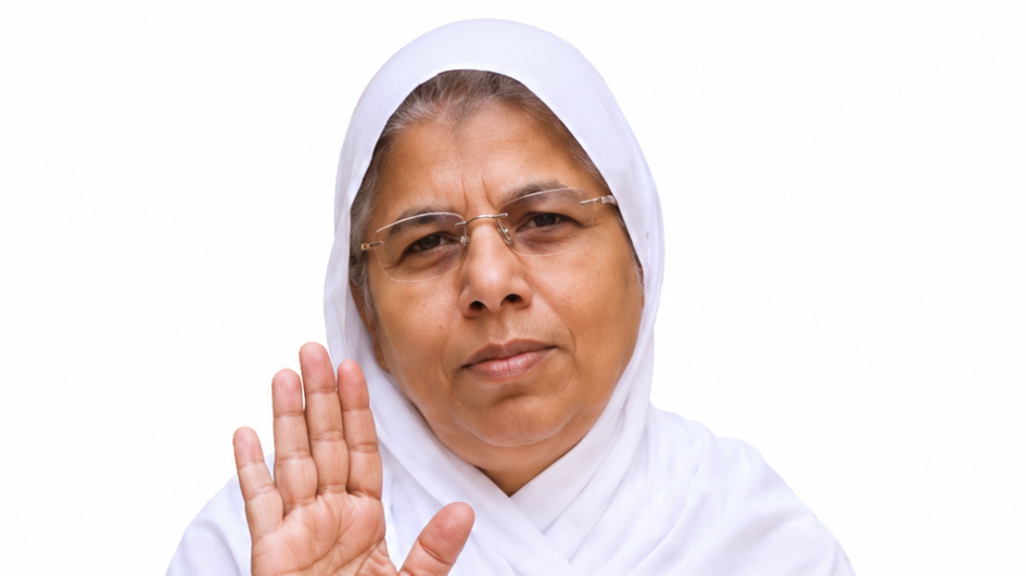 Woman in a white hijab and glasses raises her hand in a stop gesture, looking at the camera.