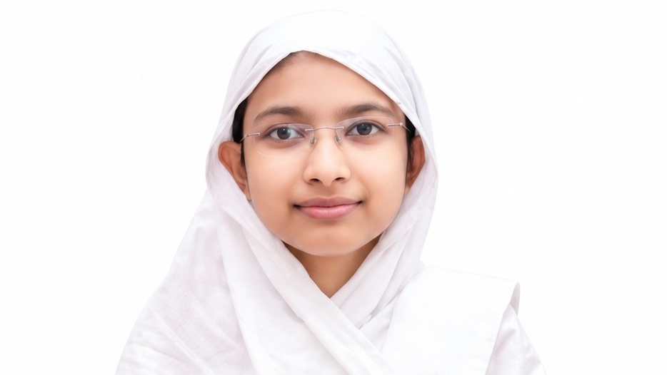 Portrait of a girl wearing a white hijab and glasses, smiling at the camera against a plain white background.