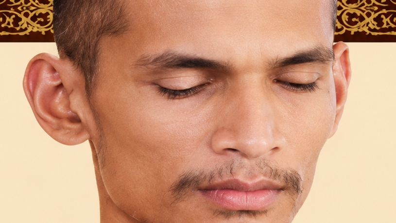 Close-up of a man with eyes closed and a calm, focused expression, suggesting meditation.