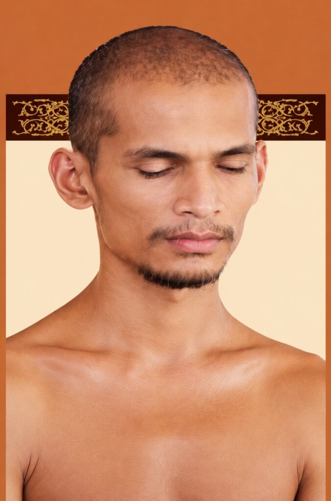Man with a shaved head and light stubble, eyes closed, shoulders bare, posed against an orange backdrop with a brown decorative stripe.
