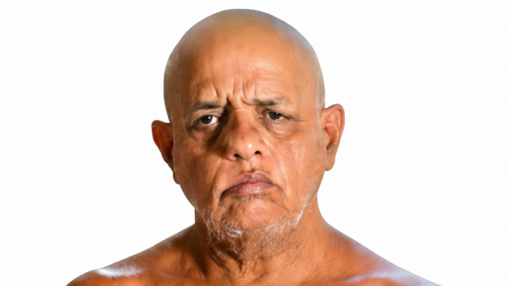 Close-up of a bald, shirtless older man with a stern, furrowed expression against a white background.