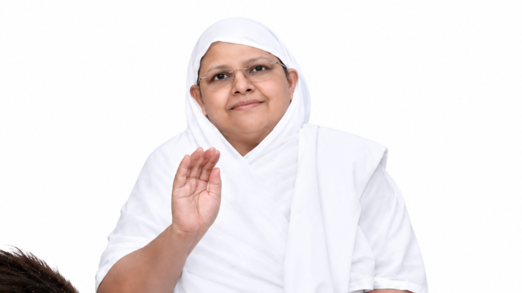 Woman wearing a white hijab and glasses waves hello with a gentle smile.