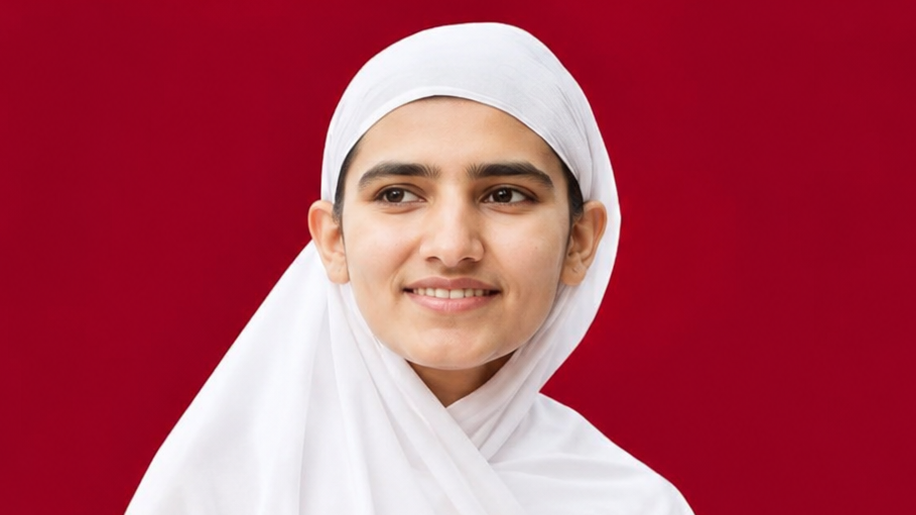 Young girl in a white headscarf smiling against a red background.