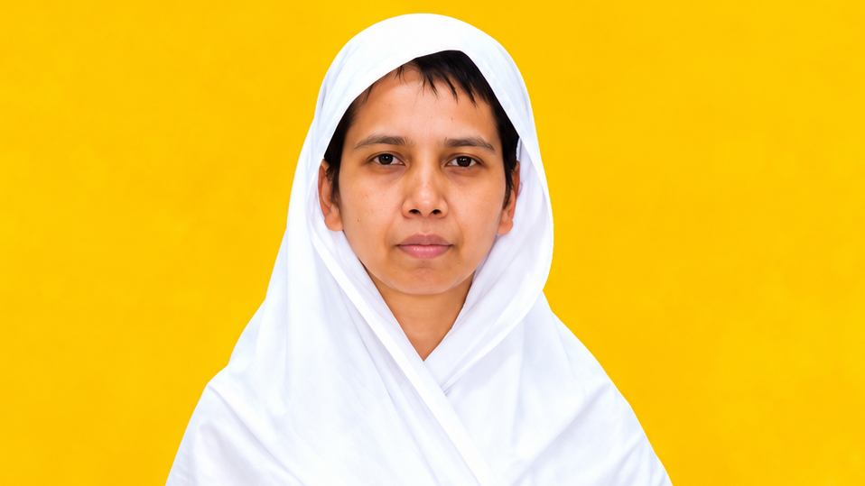 Portrait of a person wearing a white hijab against a solid yellow background, looking at the camera.