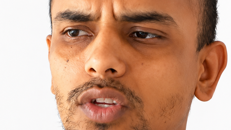 Close-up of a man with a puzzled expression, furrowed brow, looking to the left.