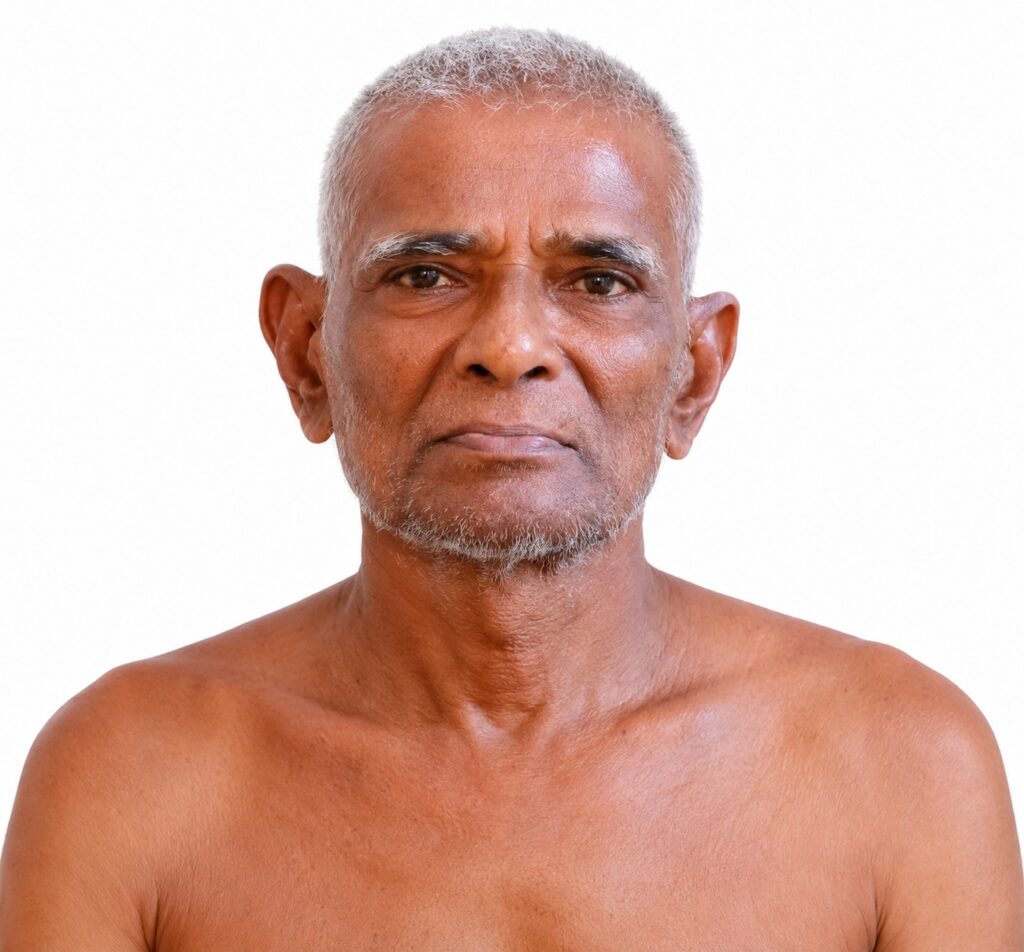 Portrait of an older man with short gray hair and stubble against a white background, bare shoulders visible.