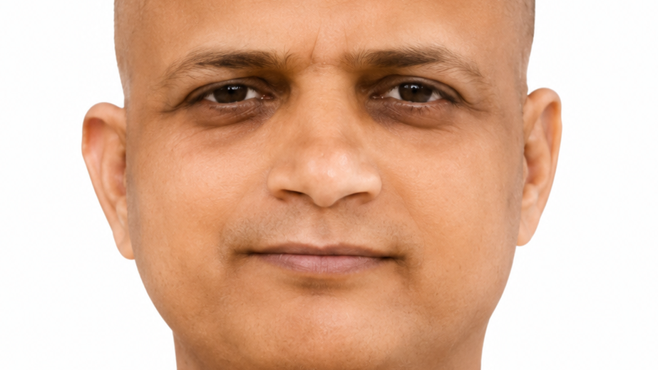 Close-up portrait of a man with a neutral expression, cropped to show face from forehead to chin against a white background.