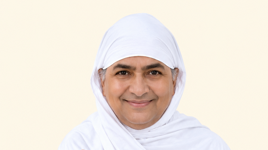 Smiling woman wearing a white hijab against a pale background.