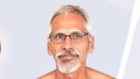 Portrait of a middle-aged man with gray hair and a trimmed beard, wearing glasses and looking at the camera.